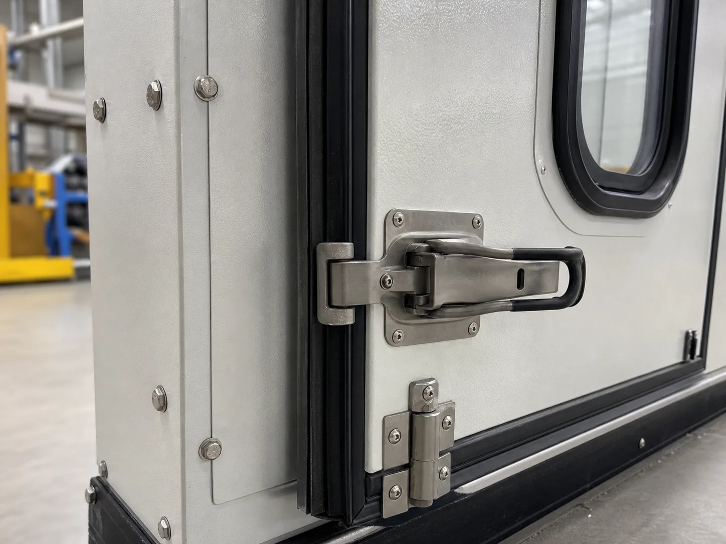 Industrial acoustic enclosure door latch and acoustic seal detail